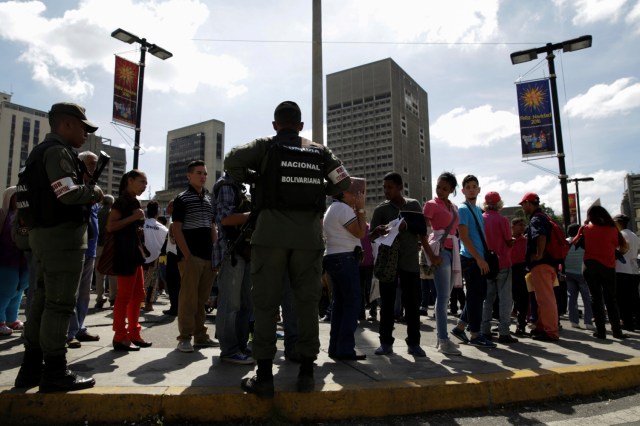 Venezuelan National Guard members control the crowd as people queue to deposit their 100 bolivar notes, near Venezuela's Central Bank in Caracas, Venezuela December 16, 2016. REUTERS/Marco Bello