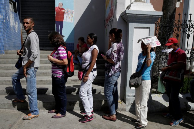 People queue to deposit their 100 bolivar notes, near Venezuela's Central Bank in Caracas, Venezuela December 16, 2016. REUTERS/Marco Bello