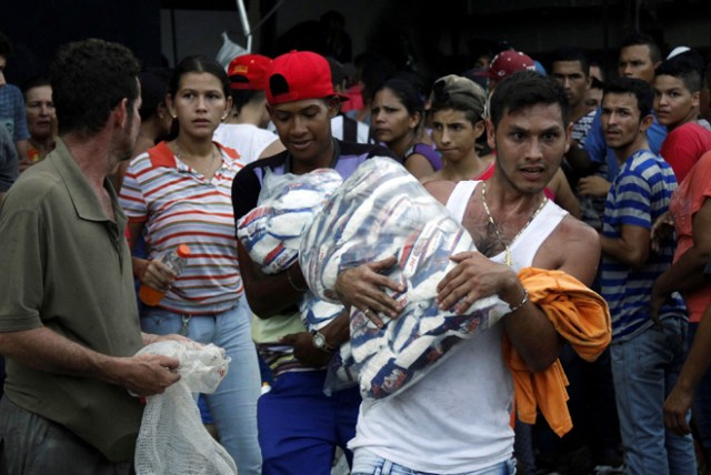 People carry goods taken from a supermarket after it was broken into, in La Fria, Venezuela December 17, 2016. REUTERS/Carlos Eduardo Ramirez
