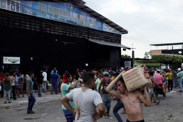 People carry goods taken from a food wholesaler after it was broken into, in La Fria, Venezuela December 17, 2016. REUTERS/Carlos Eduardo Ramirez