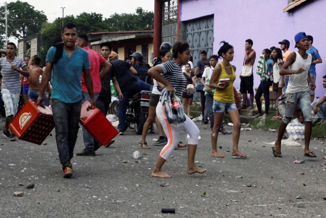 People carry goods taken from a food wholesaler after it was broken into, in La Fria, Venezuela December 17, 2016. REUTERS/Carlos Eduardo Ramirez