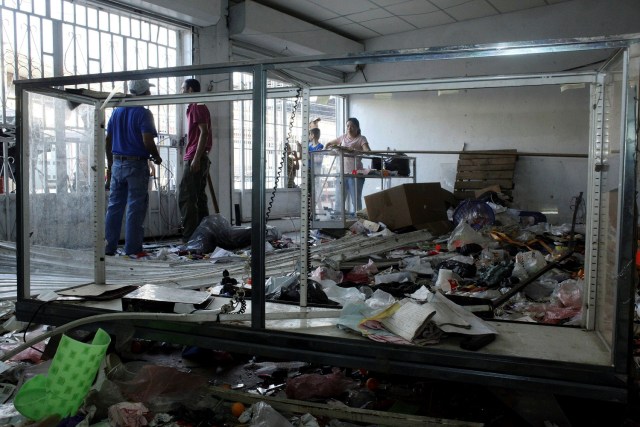 Workers repair damages in a store after it was looted, in La Fria, Venezuela, December 19, 2016. REUTERS/Carlos Eduardo Ramirez