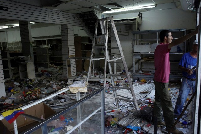 Workers repair damages in a store after it was looted, in La Fria, Venezuela, December 19, 2016. REUTERS/Carlos Eduardo Ramirez