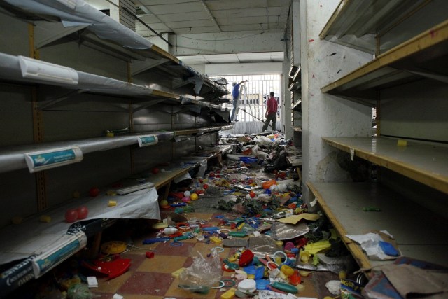 Workers repair damages in a store after it was looted, in La Fria, Venezuela, December 19, 2016. REUTERS/Carlos Eduardo Ramirez