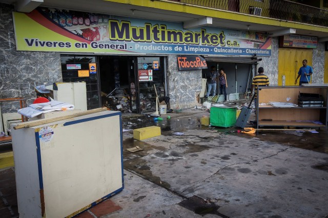 Employees clean and look for valuables in a store after it was looted in Ciudad Bolivar, Venezuela December 19, 2016. REUTERS/William Urdaneta EDITORIAL USE ONLY. NO RESALES. NO ARCHIVE.