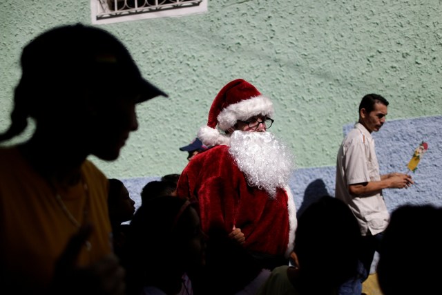 Santa Claus walks during a visit to residents of the slum of Petare in Caracas, Venezuela, December 11, 2016. Picture taken December 11, 2016. REUTERS/Ueslei Marcelino