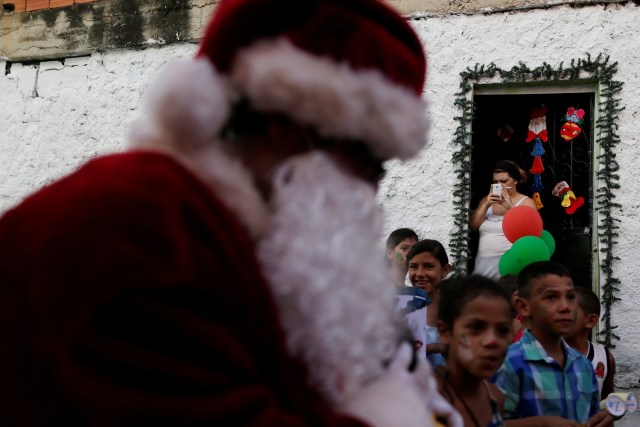 Santa Claus walks during a visit to residents of the slum of Petare in Caracas, Venezuela, December 11, 2016. Picture taken December 11, 2016. REUTERS/Ueslei Marcelino