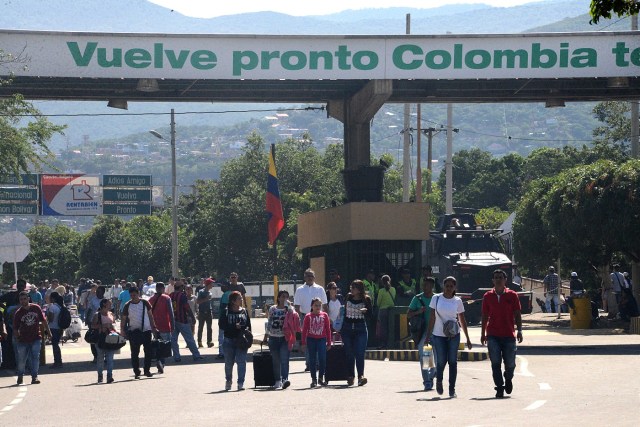 People cross the Simon Bolivar international bridge from San Antonio del Tachira, Venezuela to Norte de Santander province, Colombia, on December 20, 2016. Venezuela reopened Tuesday a border crossing with Colombia that it had closed as part of a messy crackdown on what it called currency hoarders. / AFP PHOTO / GEORGE CASTELLANOS