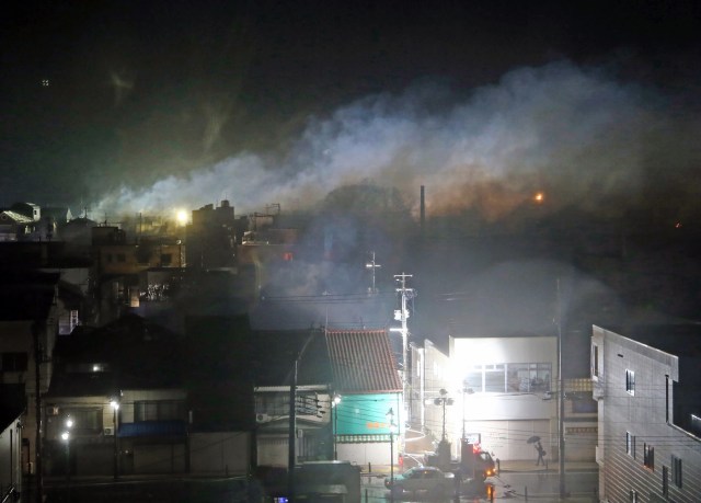 Smoke rises as firefighters control a blaze that engulfed multiple buildings at Itoigawa city, Niigata prefecture on December 22, 2016.         A rapidly-spreading fire engulfed more than 100 buildings and sparked evacuations in a northern Japanese city on December 22, leaving two injured and forcing authorities to mobilise troops. / AFP PHOTO / JIJI PRESS / JIJI PRESS / Japan OUT