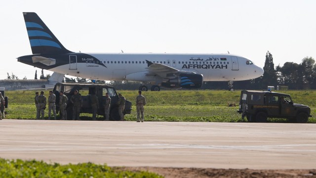Tropas maltesas inspeccionan a un avión secuestrado de Afriqiyah Airways en la pista del aeropuerto de Malta. 23 de diciembre 2016. Un avión que realizaba un vuelo interno en Libia fue secuestrado y desviado a Malta en donde aterrizó, dijeron medios malteses.REUTERS/Darrin Zamit-Lupi