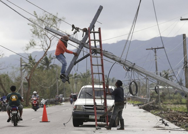 FRM210 POLANGUI (FILIPINAS) 26/12/2016.- Operarios filipinos reparan un poste caido por el paso del tifón Nock-Ten por la localidad de Polangui, provincia de Albay (Filipinas) hoy, 26 de diciembre de 2016. Al menos tres personas han muerto en Filipinas durante el paso del tifón Nock-Ten que continúa hoy su avance por el archipiélago con fuertes vientos y copiosas lluvias, informan las autoridades locales. EFE/Zalrian Sayat