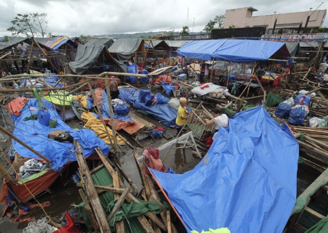 FRM210 POLANGUI (FILIPINAS) 26/12/2016.- Varios comerciantes recuperan mercancía entre los escombros de un mercado dañado por el paso del tifón Nock-Ten por la localidad de Polangui, provincia de Albay (Filipinas) hoy, 26 de diciembre de 2016. Al menos tres personas han muerto en Filipinas durante el paso del tifón Nock-Ten que continúa hoy su avance por el archipiélago con fuertes vientos y copiosas lluvias, informan las autoridades locales. EFE/Zalrian Sayat