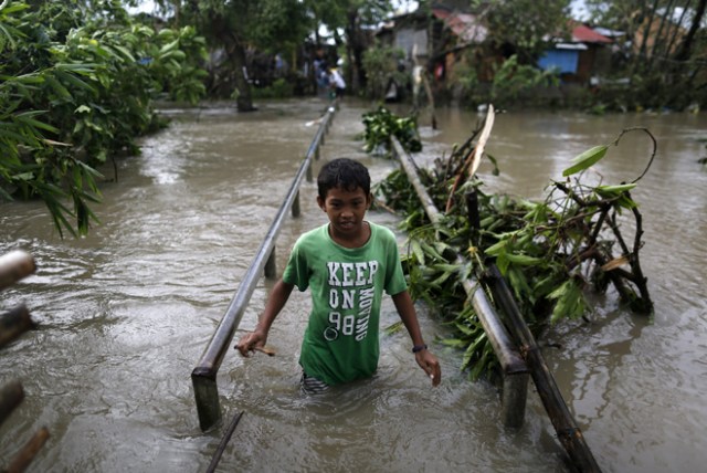 FRM229 PAMPLONA (FILIPINAS) 26/12/2016.- Un adolescente cubre una zona inundada por el paso del tifón Nock-Ten por la localidad de Pamplona, Camarines Sur (Filipinas), hoy, 26 de diciembre de 2016. Al menos tres personas han muerto en Filipinas durante el paso del tifón Nock-Ten que continúa hoy su avance por el archipiélago con fuertes vientos y copiosas lluvias, informan las autoridades locales. EFE/Francis R. Malasig