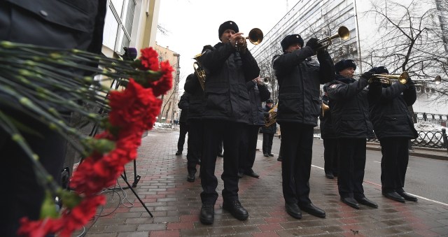 Russian police orchestra musicians pay tribute in front of the home stage building of the Alexandrov Ensemble (The Red Army Choir), in Moscow on December 26, 2016. The Russian military plane crashed on its way to Syria on December 25, with no sign of survivors among the 92 onboard, who included dozens of Red Army Choir members heading to celebrate the New Year with troops. Russia's defence ministry said a body had been recovered from the Black Sea. / AFP PHOTO / Natalia KOLESNIKOVA
