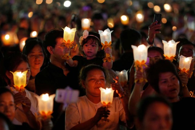 Thais hold candle lights as they pray to celebrate the new year at Sanam Luang park in Bangkok, Thailand January 1, 2017. REUTERS/Chaiwat Subprasom