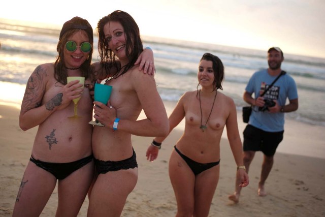 Topless women pose with alcoholic beverages along the shoreline of Sydney's Bondi Beach as they welcome the first sunrise of 2017 following new year celebrations in Australia's largest city, January 1, 2017. REUTERS/Jason Reed TEMPLATE OUT