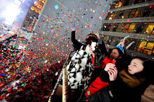 Revelers take photos and celebrate as confetti falls just after midnight during New Year celebrations in Times Square in New York, January 1, 2017. REUTERS/Mark Kauzlarich