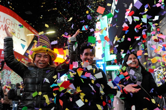 People play in confetti in Times Square during New Year celebrations in New York, U.S. January 1, 2017. REUTERS/Stephanie Keith