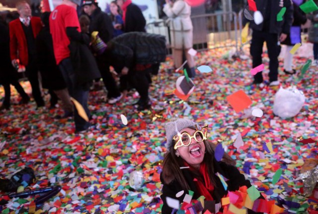 NEW YORK - JANUARY 01: A woman rolls around in confetti on New Year's eve in Times Square in New York City just after midnight on January 01, 2017.   Yana Paskova/Getty Images/AFP