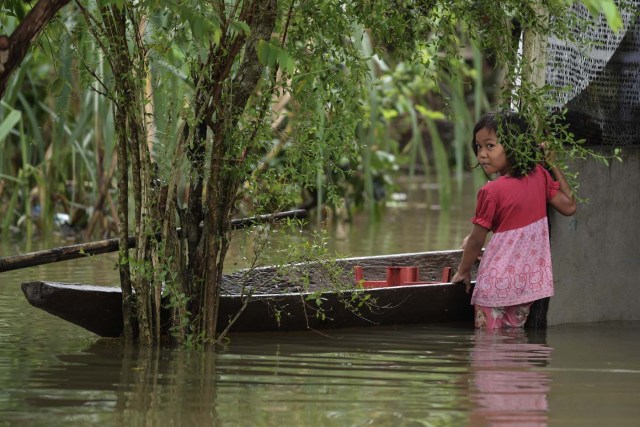 A girl plays in floodwaters in Jal Besar, Malaysia's northeastern town of Tumpat, which borders with Thailand, on January 6, 2017. More than 15,000 people remained stranded in relief centres in northern Malaysia after days of tropical downpours as thousands more headed home to survey the damage wreaked by the floods. / AFP PHOTO / Mohd RASFAN