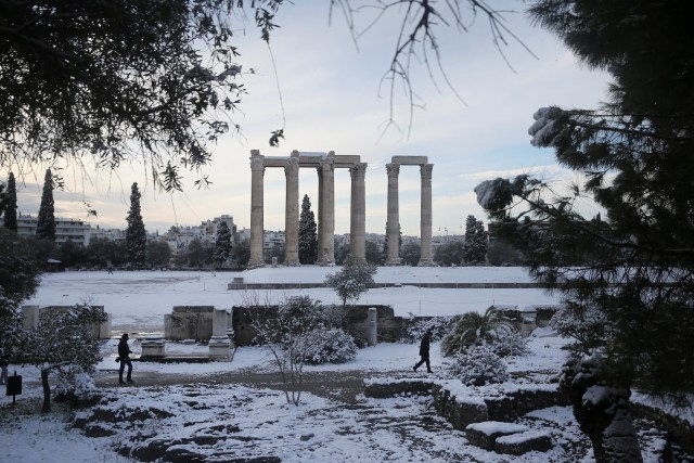 Visitors make their way inside the archaeological site of the ancient Temple of Zeus following a snowfall in Athens, Greece, January 10, 2017. REUTERS/Alkis Konstantinidis TPX IMAGES OF THE DAY