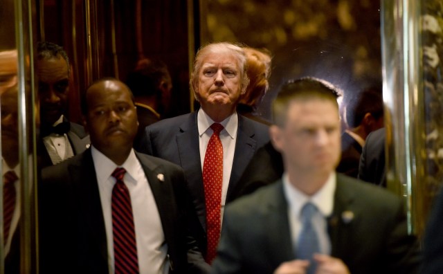 President-elect Donald Trump arrives from the elevator at Trump Tower January 9, 2017 in New York. / AFP PHOTO / TIMOTHY A. CLARY