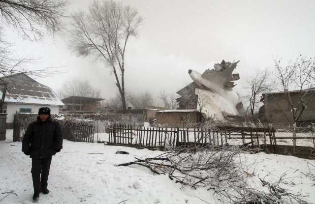 A policeman guards an area at the crash site of a Turkish cargo jet near Kyrgyzstan's Manas airport outside Bishkek, January 16, 2017. REUTERS/Vladimir Pirogov