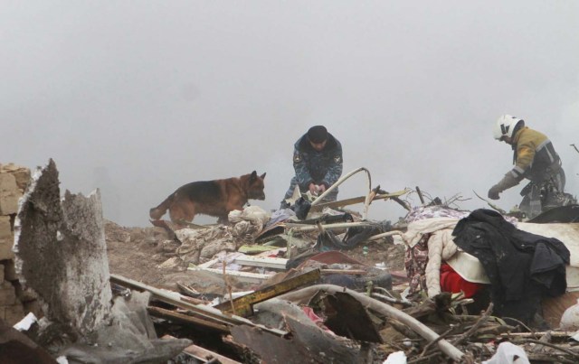 Members of a rescue team work at the crash site of a Turkish cargo jet near Manas airport outside the capital city Bishkek, Kyrgyzstan, January 16, 2017. REUTERS/Vladimir Pirogov