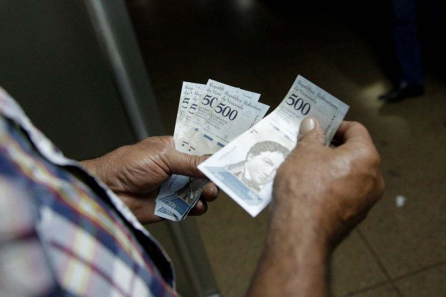 A man counts 500 bolivar banknotes in Caracas, Venezuela January 16, 2017. REUTERS/Marco Bello