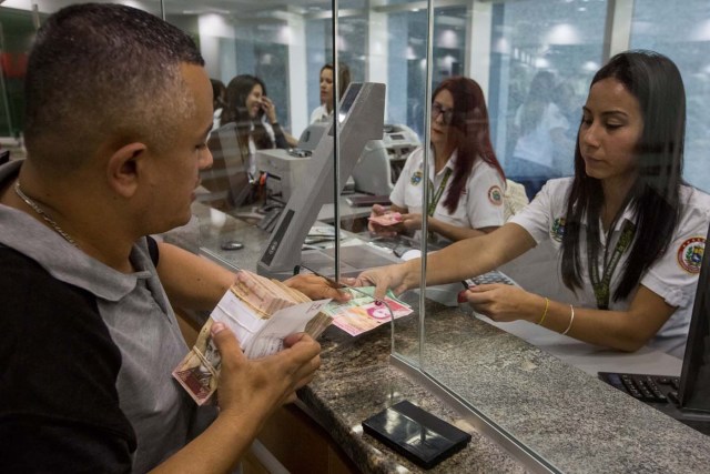 A bank employee's hands new bills of the Venezuelan currency in a bank, in Caracas, Venezuela, 16 January 2017. The new bills of 500, 5.000 and 20.000 bolivares, three of the six new Venezuelan bills start to run in the country, as it was announced by President Nicolas Maduro on 15 January 2017. EPA/Miguel Gutierrez