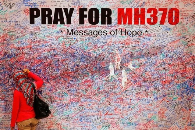Mujer deja un mensaje de esperanza en el mural de apoyo para el vuelo MH370 de Malaysia Airlines, en Kuala Lumpur, Malasia. 16/03/2014. La búsqueda en aguas profundas del desaparecido avión MH370 de Malaysia Airlines terminó el martes sin haber encontrado huella alguna de la nave, cuyo rastro se perdió en 2014 con 239 personas a bordo, dijeron los tres países involucrados es los esfuerzos. REUTERS/Damir Sagolj/Files