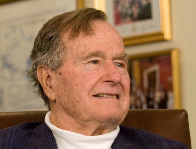 FILE PHOTO - Former President George H.W. Bush smiles as he listens to Republican presidential candidate Mitt Romney speak as he met with Bush to pick up his formal endorsement in Houston in this March 29, 2012 file photo. REUTERS/Donna Carson/File Photo TPX IMAGES OF THE DAY