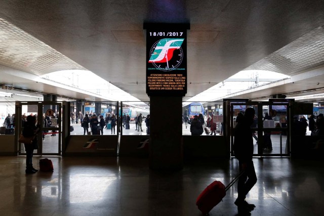 Commuters stands at Termini central train station as a billboard advises that some trains will be disrupted following an earthquake in Rome, Italy, January 18, 2017.  REUTERS/Alessandro Bianchi