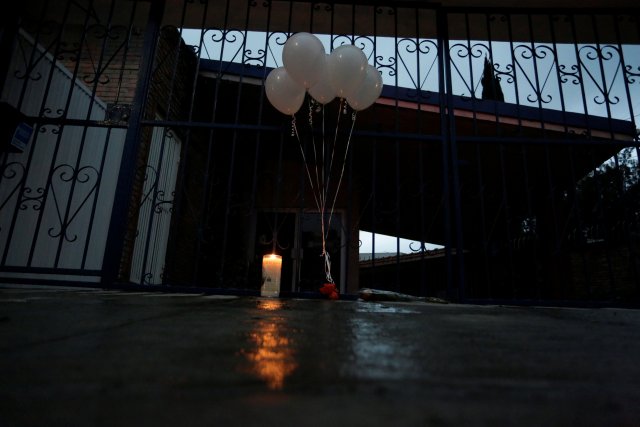 A candle and white balloons are seen outside the Colegio Americano del Noreste after a teenage student suffering from depression shot several students and a teacher at the private school on Wednesday before killing himself, in Monterrey, Mexico, January 18, 2017. REUTERS/Daniel Becerril