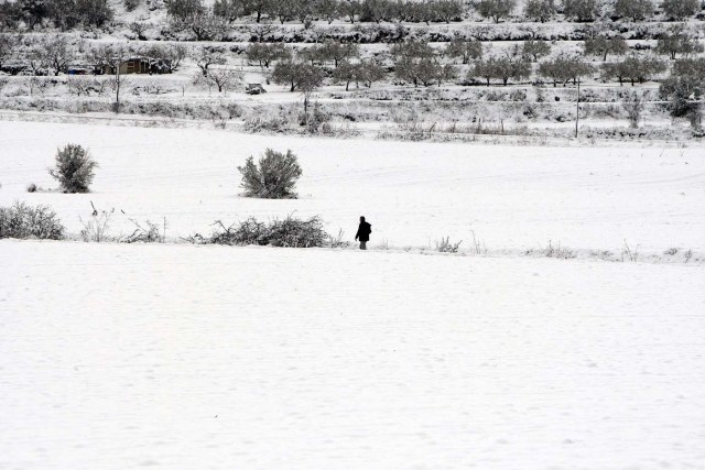 GRA221. BENASSAU (ALICANTE), 18/01/2017.- Un hombre camina hoy por la nieve en el municipio alicantino de Benassau. EFE/Morell