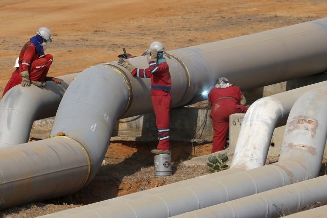 FILE PHOTO: Oil workers weld a pipeline at PDVSA's Jose Antonio Anzoategui industrial complex in the state of Anzoategui, Venezuela, April 15, 2015. REUTERS/Carlos Garcia Rawlins/File Photo