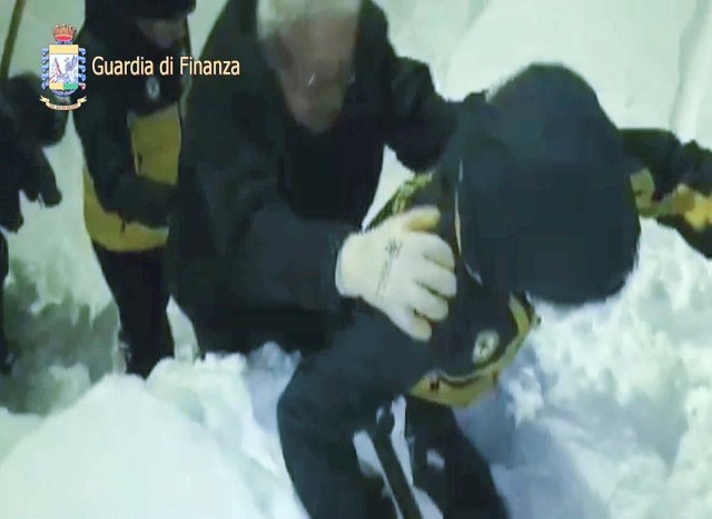A photo taken from a video shows a survivor, helped by rescuers, coming out from Hotel Rigopiano in Farindola, central Italy, hit by an avalanche, in this January 19, 2017 handout picture provided by Italy's Finance Police. Guardia Di Finanza/Handout via REUTERS   ATTENTION EDITORS - THIS IMAGE WAS PROVIDED BY A THIRD PARTY. EDITORIAL USE ONLY.