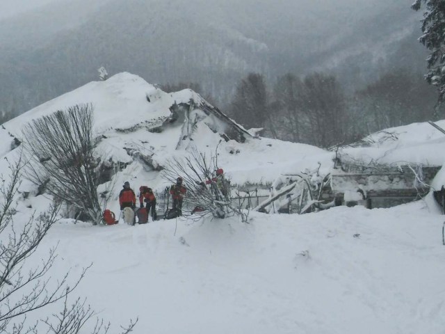 Members of Lazio's Alpine and Speleological Rescue Team stand in front of the Hotel Rigopiano in Farindola, central Italy, hit by an avalanche, in this January 19, 2017 handout picture provided by Lazio's Alpine and Speleological Rescue Team. Soccorso Alpino Speleologico Lazio/Handout via REUTERS ATTENTION EDITORS - THIS IMAGE WAS PROVIDED BY A THIRD PARTY. EDITORIAL USE ONLY. NO RESALES. NO ARCHIVE.