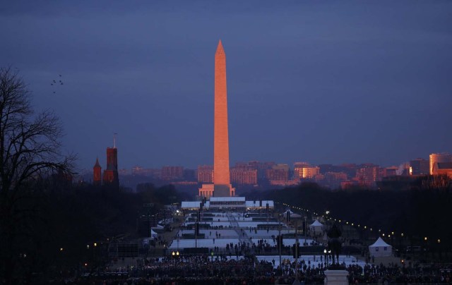 The early morning sun lights up the Washington Monument as people gather on the National Mall prior to the inauguration of U.S. President-elect Donald Trump in Washington, U.S., January 20, 2017. REUTERS/Kevin Lamarque