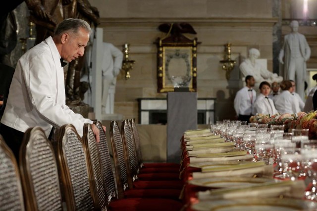 A head waiter makes final checks of a table prepared for U.S. President Donald Trump and members of Congress before the Inaugural Luncheon in Statuary Hall on Capitol Hill in Washington, U.S., January 20, 2017. REUTERS/Yuri Gripas