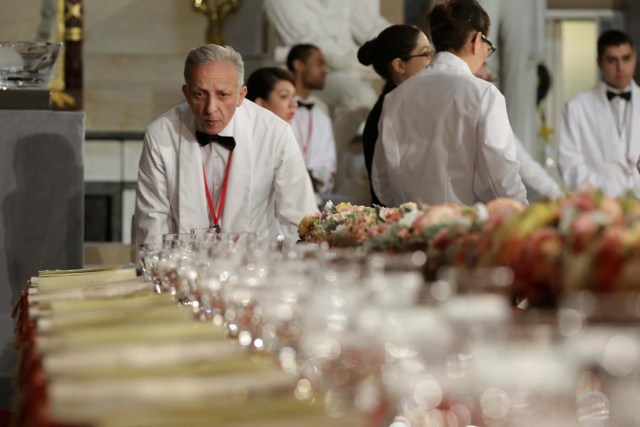 A head waiter makes final checks of a table prepared for U.S. President Donald Trump and members of Congress before the Inaugural Luncheon in Statuary Hall on Capitol Hill in Washington, U.S., January 20, 2017. REUTERS/Yuri Gripas