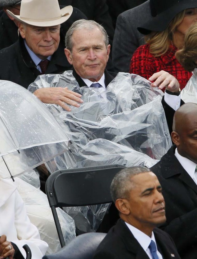 Former President George W. Bush takes off his cover under the rain during the inauguration ceremonies swearing in Donald Trump as the 45th president of the United States on the West front of the U.S. Capitol in Washington, U.S., January 20, 2017. REUTERS/Rick Wilking