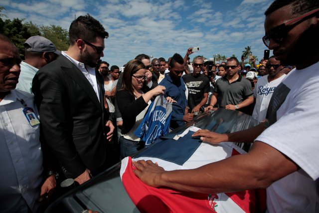 Mourners put a Dominican Republic flag and a jersey of Yordano Ventura on the coffin of Ventura, a Kansas City Royals baseball player who died in a car crash, during the funeral at the Municipal Baseball Stadium of Las Terrenas