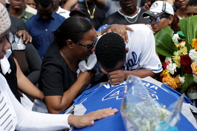 Relatives of Yordano Ventura, a Kansas City Royals baseball player who died in a car crash, cry on the coffin during the funeral at the Municipal Baseball Stadium of Las Terrenas, Dominican Republic