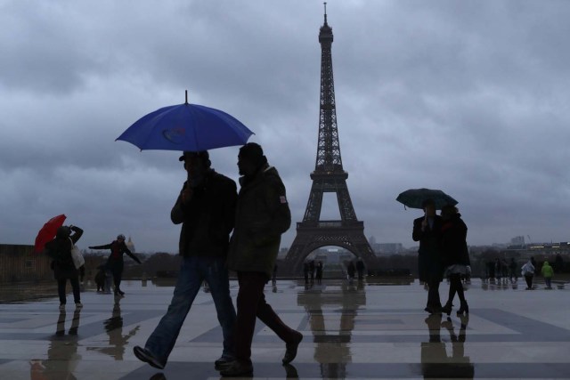 People protect themselves from the rain under umbrellas at Trocadero square near the Eiffel Tower in Paris, France, January 12, 2017. REUTERS/Gonzalo Fuentes