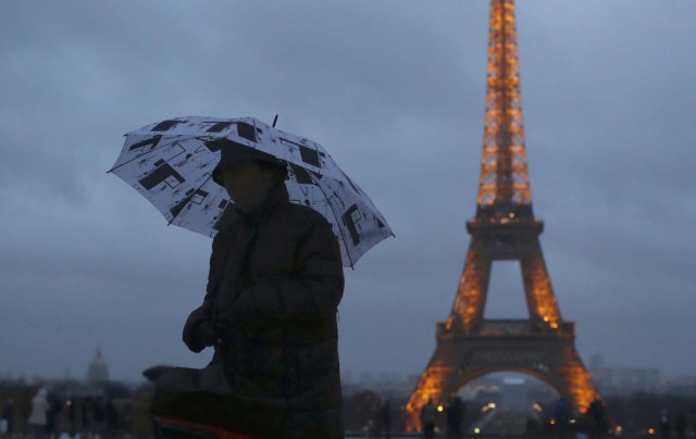 A woman holds an umbrella to protect herself from the rain at the Trocadero Square near the Eiffel Tower in Paris, France, January 12, 2017.  REUTERS/Gonzalo Fuentes