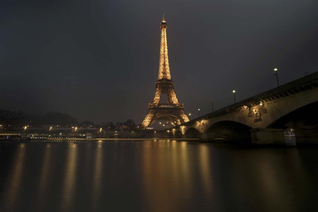 A streak of light from a passing boat is seen in this long time-exposure of the illuminated Eiffel Tower and the Seine River in Paris, France, January 17, 2017. REUTERS/Philippe Wojazer