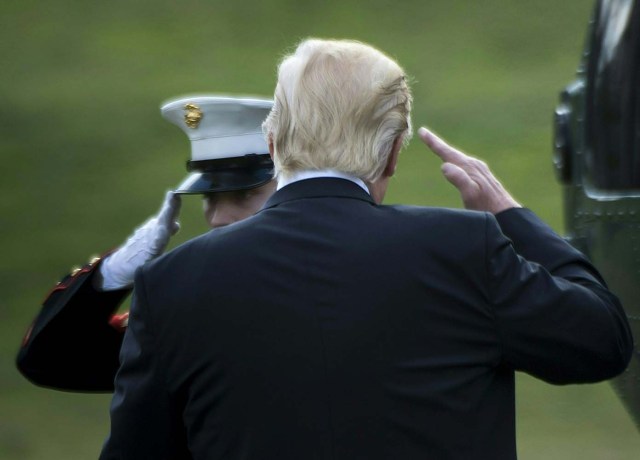 US President Donald Trump salutes as he boards Marine One for his first trip to Philadelphia as president, on the South Lawn of the White House January 26, 2017 in Washington, DC. / AFP PHOTO / Brendan Smialowski
