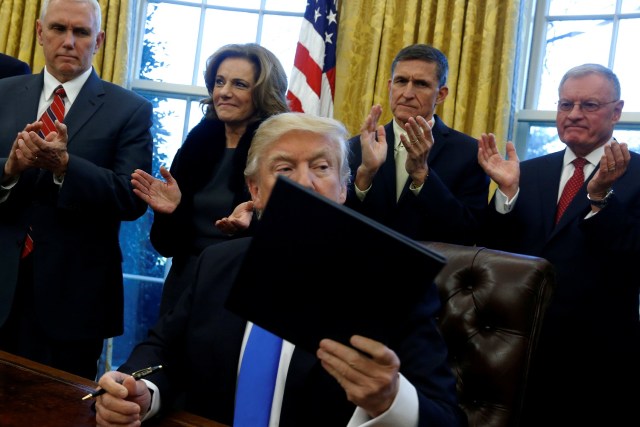 U.S. Vice President Mike Pence (from L-R, 2nd row), Deputy National Security Advisor K. T. McFarland, National Security Advisor Michael Flynn and National Security Council Chief of Staff Keith Kellogg applaud after President Donald Trump signed a memorandum to security services directing them to defeat the Islamic State in the Oval Office at the White House in Washington, U.S. January 28, 2017. REUTERS/Jonathan Ernst