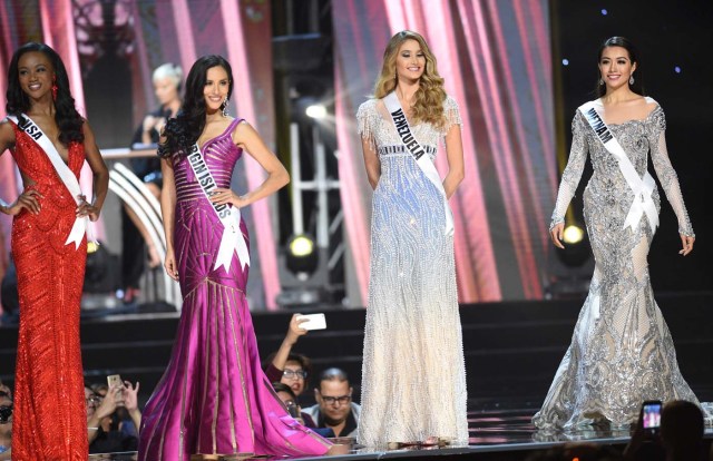 This photo taken on January 26, 2017 shows Miss Universe contestant Le Hang (R) of Vietnam in her long gown along with other candidates during the preliminary competition of the Miss Universe pageant at the Mall of Asia arena in Manila. / AFP PHOTO / TED ALJIBE